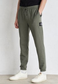 Calvin Klein Jeans - TECHNICAL BADGE PANT - Pantaloni sportivi - dusty olive Immagine in miniatura 1