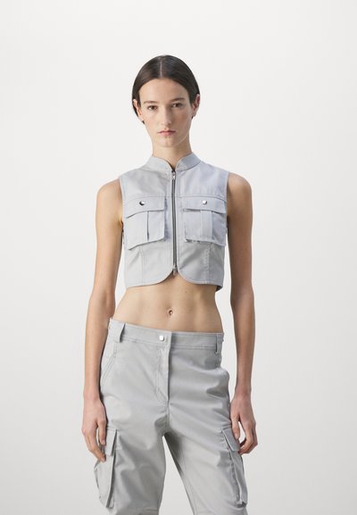 Gray cropped vest with a high collar, featuring dual front pockets and a front zipper. The material has a smooth, soft texture.