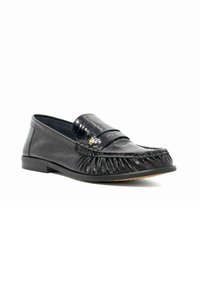 Zwarte loafer met een glanzende, gestructureerde afwerking, voorzien van een fringed voorkant en een kleine decoratieve hardwareaccent. Platte zool en gladde voering.
