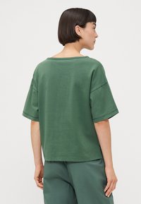 Groen oversized T-shirt met korte mouwen, ronde hals en zachte stof. Eenvoudig ontwerp zonder zichtbare patronen of hardwaredetails.