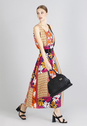Abito maxi con un motivo floreale e geometrico colorato, dotato di vita aderente, cintura nera, abbinato a una borsa a tracolla nera intrecciata e tacchi.