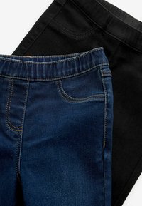 Denim jeans in donkerblauw en zwart. Donkerblauw met klassieke stiksels, zakken en een elastische tailleband; zwart heeft een gladde textuur en een vergelijkbaar ontwerp.