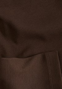 Tessuto a coste marrone con una superficie liscia e una leggera lucentezza. Presenta un bordo cucito con cura. Il materiale sembra morbido ed elastico.