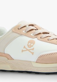 Weiße und hellrosa Sneaker mit einer strukturierten Oberfläche, die ein Logo von Totenkopf und gekreuzten Knochen an der Seite sowie gemusterte Schnürsenkel aufweisen.