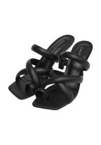 Sandales à talons noires avec des bretelles croisées et épaisses en cuir lisse. Design à bout carré avec une semelle plate et une étiquette de marque à l'intérieur.