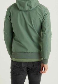 Green nylon jacket with a hood, featuring a textured mesh hem and elastic cuffs. Smooth finish and subtle stitching details.