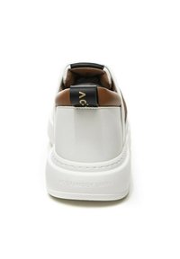 Sneaker bianca con dettagli in pelle marrone, colletto imbottito e linguetta nera con logo dorato. Materiale liscio e suola spessa.