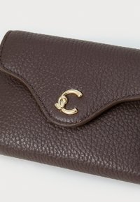 Portafoglio in pelle marrone con finitura texture, dotato di una chiusura a scatto di colore oro a forma di C e un'apertura a soffietto curva. Design compatto e slanciato.