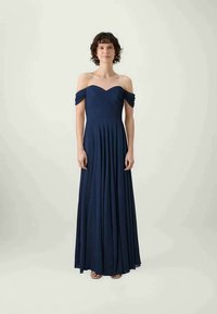 Abito da sera blu navy con spalle scoperte, dotato di un corpetto plissettato e una gonna fluente. Realizzato in un tessuto morbido, presenta una vita aderente.
