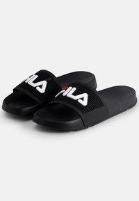 Mustat liukukengät, joissa on rei'itetty hihna, jossa näkyvä valkoinen "FILA" -brändäys ja teksturoitu, pehmustettu pohja mukavuutta varten.