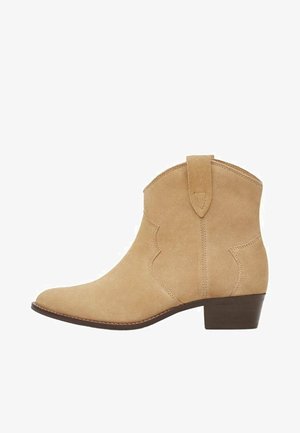 Beżowe botki zamszowe za kostkę z niskim, grubym obcasem, pętelką do ściągania i ozdobnym przeszyciem, stylizowane na wzór western.