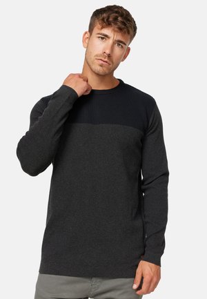 Suéter gris oscuro con un cuerpo texturizado y un panel superior liso y sólido. Mangas largas y un escote redondo con un sutil detalle de marca.