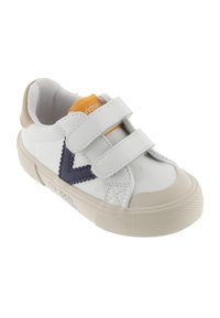 Sneaker bianca con accenti beige, suola in gomma testurizzata, cinturini in velcro e cuciture decorative blu scuro a forma di V. Interno in tessuto morbido.