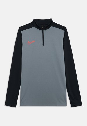 Haut à zip quart Nike en gris et noir. Doté de manches longues, d'un col zippé et d'un petit logo orange sur la poitrine. Texture lisse.
