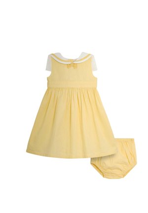 Żółta bezrękawnikowa sukienka niemowlęca z białym kołnierzem marynarskim i pasującymi żółtymi bloomersami na białym tle.