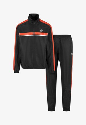 Crni trenirku napravljen od glatkog sintetičkog materijala, sa izraženim narančastim i bijelim prugama na jakni i hlačama. Elastični manžeti i pojas.