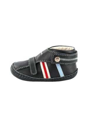 Scarpa nera in pelle con punta arrotondata, che presenta dettagli a strisce rosse e blu, una fascia in Velcro e cuciture decorative.