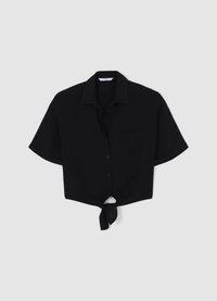 Chemise noire à manches courtes avec boutons, col ouvert, poche poitrine unique et ourlet noué à l'avant. Fabriquée en tissu lisse.