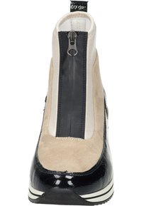 Bottines noires et beige avec fermeture éclair, en matériau en daim et en cuir verni, au design arrondi et à semelle rayée.