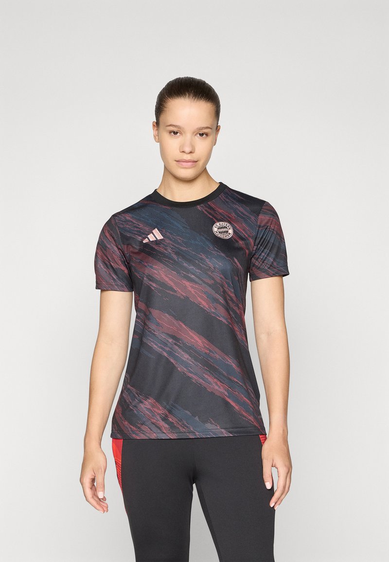Zwarte sportshirt met korte mouwen, voorzien van abstracte patronen in rood en blauw, inclusief een Adidas-logo en een cirkelvormig embleem op de linkerborst.