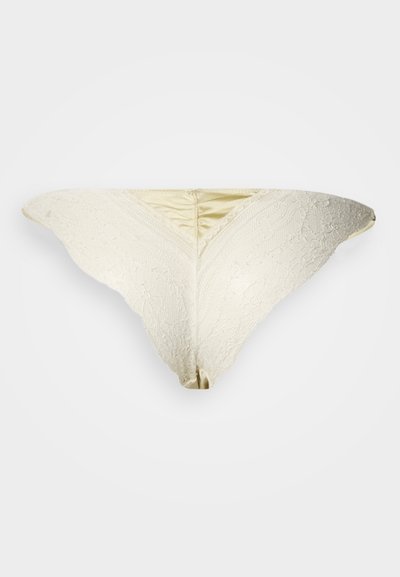 Naiste pitsist ja satiinist tangapüksikud, millel on peen pitskate kreemjas toonis, V-kujuline esikülg ja sile satiinvöö.