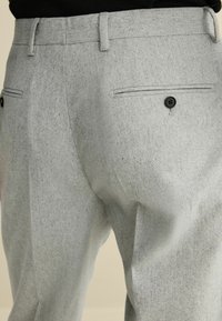 Grau gewobene Hose mit glatter Textur, geradem Schnitt, zwei Gesäßtaschen mit schwarzen Knöpfen und detailliertem Taillenbund.