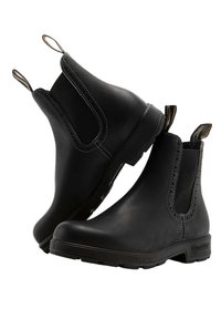 Czarne skórzane botki Chelsea mają elastyczne panele boczne, pętle, a także fakturowaną gumową podeszwę. Widoczne są szczegóły przeszycia wzdłuż krawędzi.