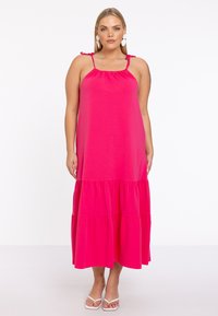 Pink tiered Maxikleid mit verstellbaren Spaghettiträgern und gerafftem Ausschnitt. Hergestellt aus leichtem Stoff, der eine glatte Textur zeigt.