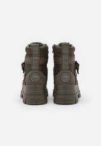 Paio di stivali alti Buffalo color verde oliva con suole spesse, cerniere posteriori e linguette e loghi sul tallone brandizzati, mostrati da dietro.