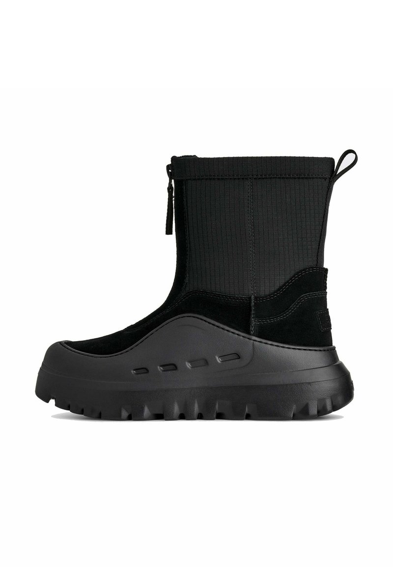 Stivaletto nero alla caviglia con tomaia in tessuto texturizzato, dettagli in camoscio, punta arrotondata e suola spessa in gomma con tasselli pronunciati.