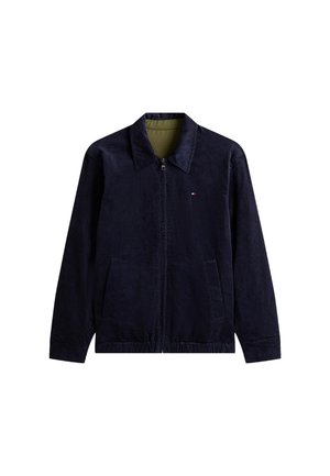 Marineblauwe corduroyjas met een kraag, ritssluiting aan de voorkant en twee zijzakken. Heeft een gestructureerde stof en een contrasterende groene voering.