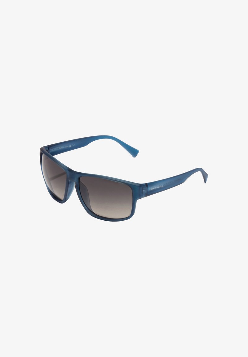 Gafas de sol de plástico azul con lentes grises degradados, de forma rectangular y varillas resistentes. Presentan un acabado mate y un detalle sutil de la marca en la patilla.