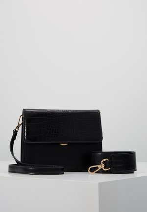 Borsa nera con fronte in stampa coccodrillo, corpo liscio, chiusura magnetica, tracolla staccabile, hardware in tonalità oro, forma rettangolare.
