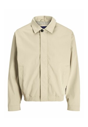 Beige lättviktsjacka med krage, knappstängning fram, sidofickor och elastiska ärmmuddar för en avslappnad passform. Texturerad tyg.