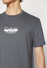 Calvin Klein CUT THROUGH LOGO - T-shirts med print - iron gate