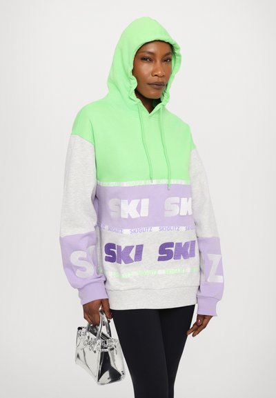 Color-blocked hooded sweatshirt in mint green, light gray, and lavender. Features "SKI" graphics in contrasting colors. Soft cotton blend material.