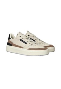 Beige leren sneakers met bruin suède accenten, textuuroverlay, zwarte hiel detail en een witte platformzool. Voorzien van een vetersluiting.