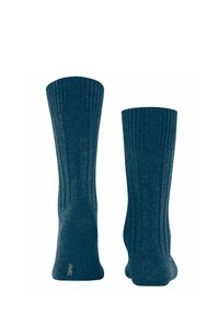 Dunkelblaue gerippte Socken mit einer weichen Textur, die einen Logo-Stich an der Ferse aufweisen. Das Design betont vertikale Linien für zusätzliche Details.