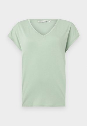 Miętowa koszulka typu V-neck z krótkim rękawem, wykonana z miękkiego materiału, o luźnym kroju, bez wzorów i widocznych elementów metalowych.