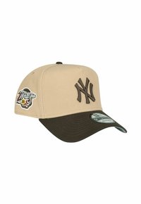 Beige Baseballkappe mit einem dunkelbraunen Schirm, ausgestattet mit einem erhabenen braunen "NY"-Logo und einem World Series-Patch an der Seite. Texturiertes Material.