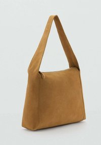 Sac à épaule en daim marron avec une texture douce et lisse, une seule sangle et une forme rectangulaire. Doté d'une fermeture éclair sur le dessus.