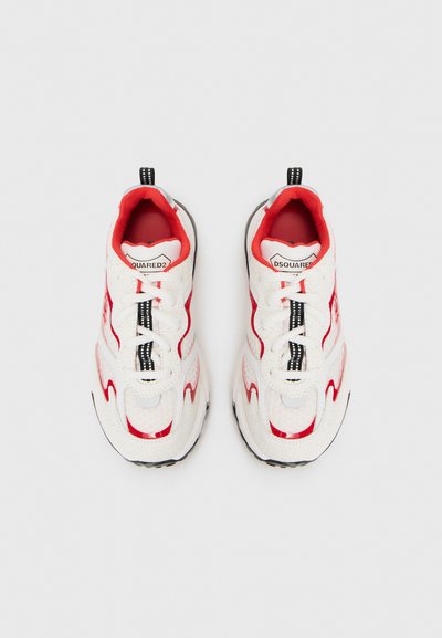 Baskets de sport blanches et rouges avec surfaces texturées, design à lacets, accents noirs et semelle en caoutchouc. Présentent une doublure en tissu et un logo.