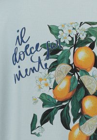 Il tessuto azzurro chiaro presenta un motivo colorato con frutti arancioni, foglie verdi, fiori bianchi e il testo "il dolce far niente."