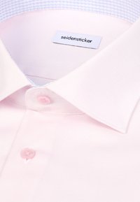 Camicia da uomo rosa chiaro con una trama a tessuto, caratterizzata da un colletto button-down e da una piccola etichetta del marchio cucita. Presenta un dettaglio di colletto interno azzurro pallido.