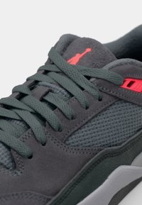 Sive teniske z usnjem, mrežastimi paneli, sivimi vezalkami in rdečim poudarkom. Imajo teksturiran podplat in Jumpman logo na jeziku.