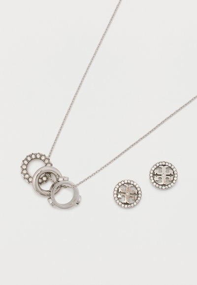 Sidabro atspalvio papuošalų rinkinys, kuris apima kaklo vėrinį su tarpusavyje susijungusiais žiedais ir atitinkamais apvaliais auskarais, papuoštais skaidriais akmenimis.
