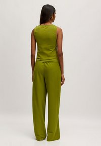 Groen sleeveless top en wijde broek van zacht, lichtgewicht materiaal. Eenvoudig ontwerp met een gladde textuur en een losse pasvorm.