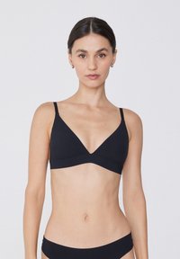 Bralette noir en triangle avec des bretelles fines et ajustables, au design sans coutures. Tissu doux avec une texture lisse, détails matériels minimaux.