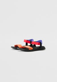 Sandales colorées avec des semelles noires, des sangles réglables rouges et oranges, et des accents violets. Texturées pour une adhérence et un confort optimaux.