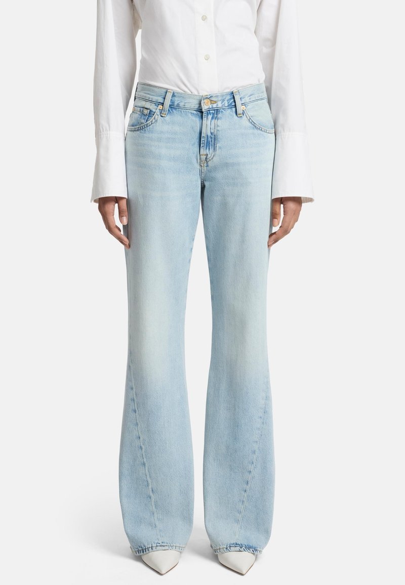 Jean flare bleu clair en denim, avec une taille mi-haute, un design traditionnel à cinq poches et un léger délavage.